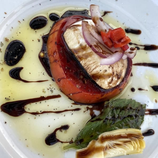 Grilled tomato and mozzarella with red onion, basil, artichoke, and balsamic glaze.